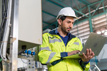 Machine engineers inspect machines and sterilizers in factories or manufacturing industries and write down the information on  laptops. Machine maintenance