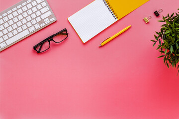 Pink flat lay top view office table desk with keyboard and office supplies
