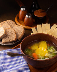 Fresh hot vegetable soup in a ceramic plate on the table