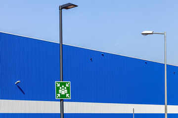 Piktogramm Sammelplatz auf einem Platz vor einer Industrieanlage