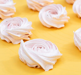 Close-up of a marshmallow on a yellow background. Selective focus.