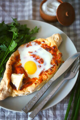 Selective focus. Khachapuri with egg. Adjarian khachapuri on a plate.