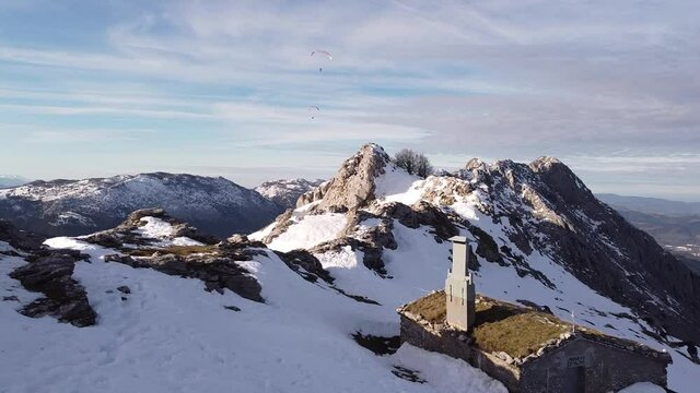 paragliders flying high over the mountains in winter (aerial video)
