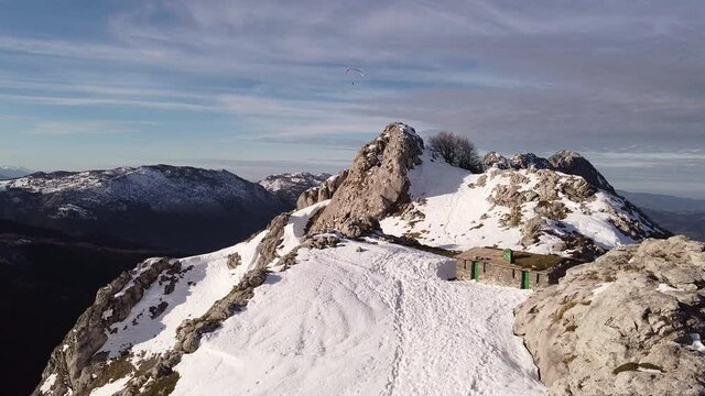 paragliders flying high over the mountains in winter (aerial video)
