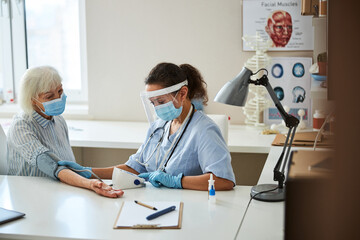 Medical worker operating a monitor during a blood pressure examination