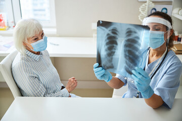 Female doctor studying an x-ray diagram with patient