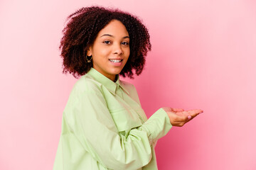 Young african american mixed race woman isolated holding a copy space on a palm.