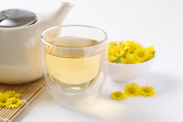 Organic Chrysanthemum flower tea in a cup and teapot on white background, Healthy Herbal drink