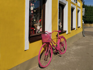 pink bicycle near the bright yellow wall of a flower shop on a street in Nizhny Novgorod, Russia