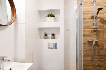 Bathroom with shower and white tiles. Interior of small bathroom with sink and faucet and mirror on...