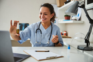 Lively doctor keeping a nasal spray bottle