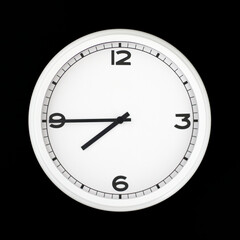 White round analog wall clock isolated on black background.