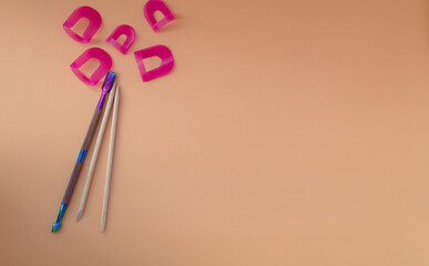on a beige background, a pusher, orange sticks for manicure. The view from the top