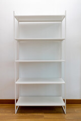 Empty shelves against a white wall.