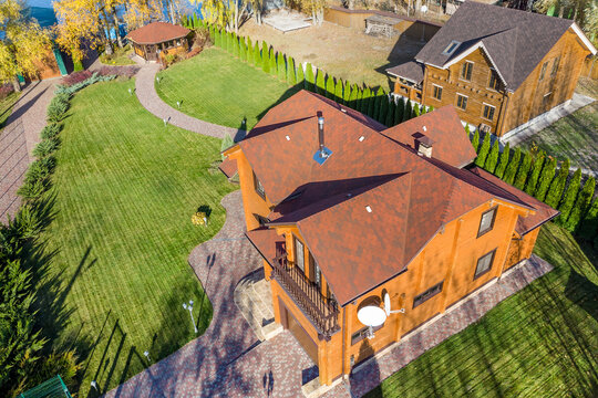 Aerial Overhead Elevated View Of Beautiful Luxury Big Wooden Modern House. Timber Cottage Villa With With Green Lawn Garden And Paved Footpath To Gazebo Arbor Backyard. Landscaping Design Development