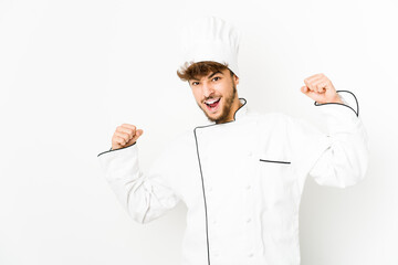 Young arab cook man raising fist after a victory, winner concept.