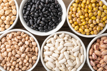 Closeup of assorted beans on white bowls