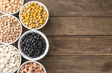 Assorted beans on white bowls with copy space