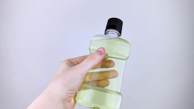 Mouthwash floating in soapy water. Harmful composition of ingredients. Rinse aid with Sodium Lauryl Sulfate. The concept of hazardous substances in cosmetics and household chemicals