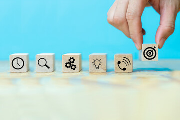 Businessman hand arranging wood block with icon business strategy