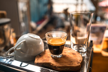 Espresso coffee is flowing into the shot cup.