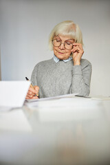 Concentrated woman looking at the documents on the desk