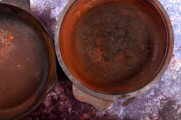 Rusty metal pans on a rustic background. Renovation of cast iron pan. Old rusty round cast iron...