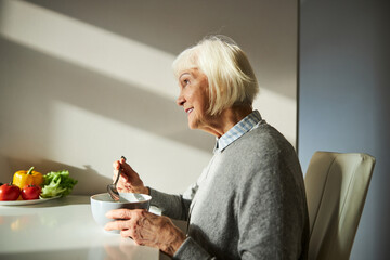 Happy female pensioner enjoying her morning meal