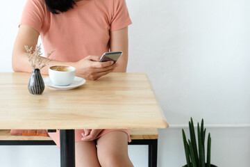 Woman holding smart phone during coffee time in the morning.