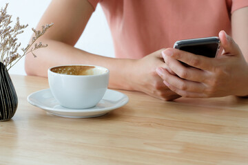 Woman holding smart phone during coffee time in the morning.