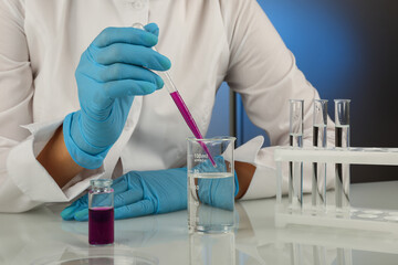 chemist dripping reagent with a pipette. conducting chemical experiments in the laboratory. chemical production concept. Researcher works with lab glassware and reagents in chemical laboratory
