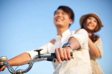 Obraz premium The young couple riding a bicycle