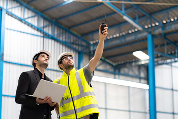 Caucasian man warehouse worker and manager head office working on laptop computer at new warehouse building. Design and decoration of storage buildings