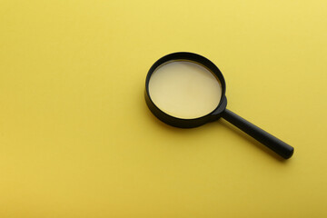 magnifier on yellow background with copy space