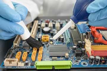 Technician use brush and air blower ball to clean dust in circuit board computer. Repair upgrade...