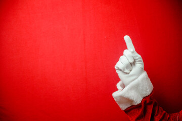 Santa Claus pointing finger on red background for Christmas time.