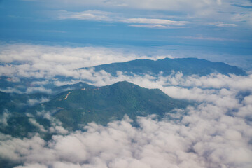 Fototapeta na wymiar High mountain hill and cloud view from airplane window