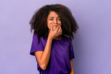 Young african american curly woman isolated on purple background doubting between two options.