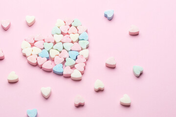 Pastel color heart of heart-shaped candy on a pink background