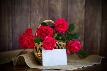 bouquet of beautiful red roses in a basket on table
