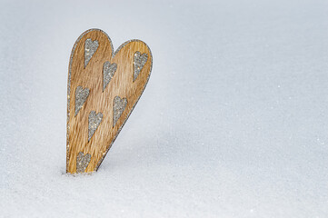 Wooden heart with many sharpen silver glittering hearts in snow