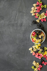 Italian farfalle pasta in bowls. Raw multicolored farfalle pasta, overhead view