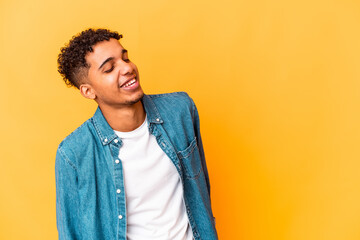 Young african american curly man isolated on purple relaxed and happy laughing, neck stretched showing teeth.