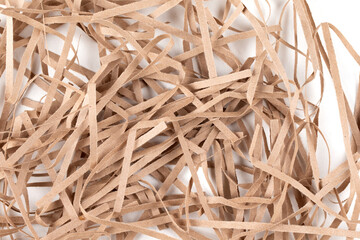 Lots of thin strips of beige paper. Decorative pieces of paper for gifts on a white background