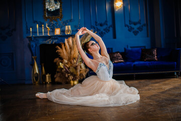 Fototapeta premium Ballerina sitting on the floor and dancing in a luxurious interior