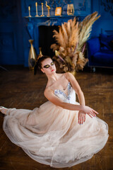 Fototapeta premium Ballerina sitting on the floor and dancing in a luxurious interior