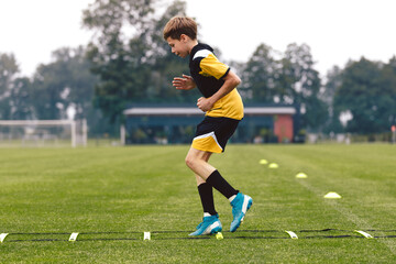 Junior football club player training on soccer ladder. Football training for sport team. Young boy...