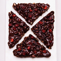 Mosaic Chocolate and Biscuit Cake with Nuts and Dried Cherries on white marble board. Chocolate and cookie dessert. Christmas delicious treat. Selective focus