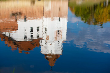 Reflection of an old castle in blue water.