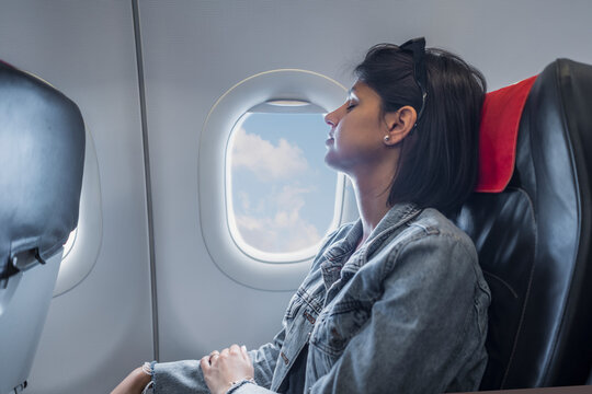 Beautiful female sleeping on airplane. Woman in plane flying long time and tired 